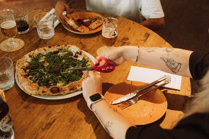 Gasten delen een Napolitaanse pizza bij restaurant Hout in Eindhoven